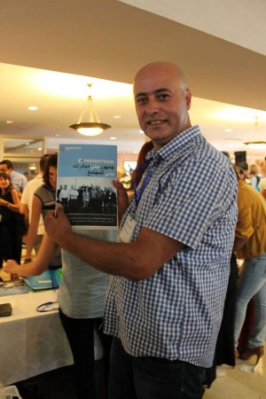 Ahmad Sheikh Muhammad, Arab Community Programs Director at PresenTense, with Launch Night program booklet; photo courtesy PresenTense Israel.