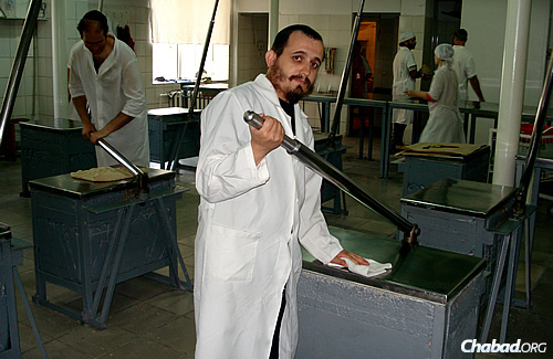 A worker cleans one of the stainless-steel kneading stations at the Dnepropetrovsk matzah bakery.