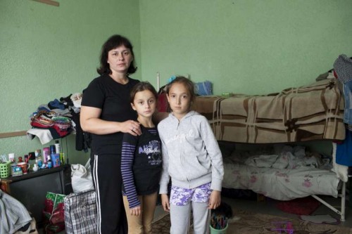 A Ukrainian mother poses with her daughter and a young friend in the room where she lives with her family in a centre for displaced people in Slavyansk. Most of the people are from the Luhansk and Donetsk regions.