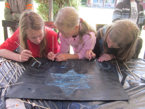 Girls from Lithuania work on a scratch magic Olameinu sign.