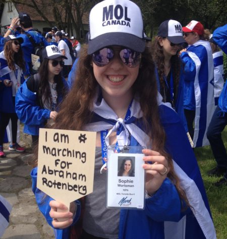 Sophie Worstman of Toronto holds a sign bearing the name of her great uncle, Holocaust victim Abraham Rotenberg, before taking part in the 2016 March of the Living from Auschwitz to Birkenau. Photo credit: Jacob Kamaras.