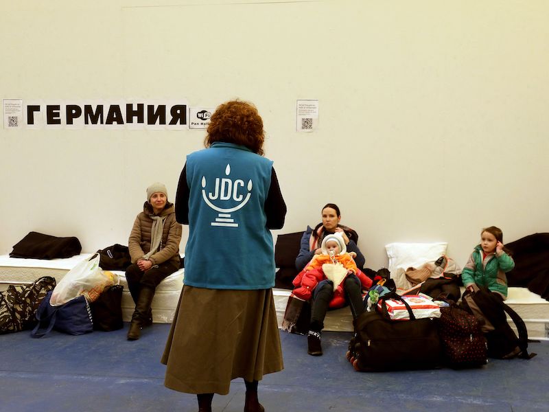 A JDC staffer helps Ukrainian Jewish refugees in Chisinau, Moldova on March 15, 2022, before they head to the airport to board a plane to Israel.