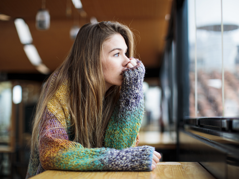 depressed girl looking out the window