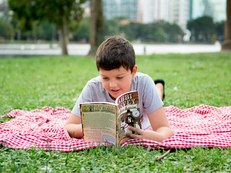 A child reading a graphic novel distributed by PJ Library.