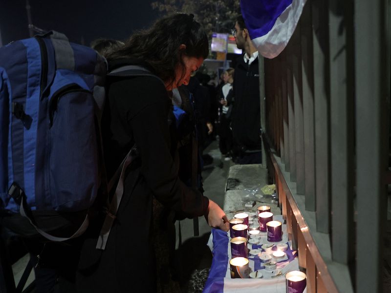 An Israeli lights candles in memory of the victims at the site of Friday's shooting attack in Jerusalem.