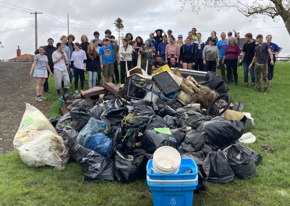 Participants in a 'reverse tashlich' stand in front of the garbage they collected from a beach in New Zealand, in an undated photograph.