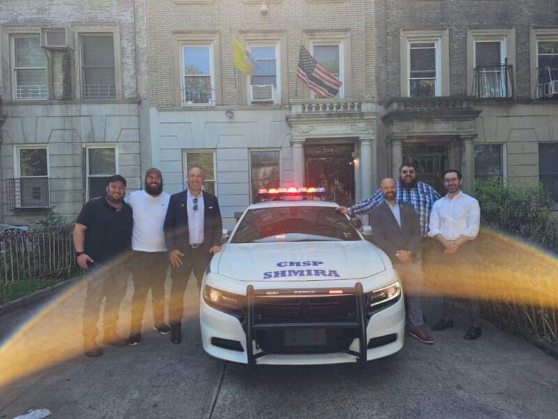 Members of Brooklyn's Crown Heights Shmira organization stand in front of a patrol car purchased for them by the Community Security Initiative in September 2023.