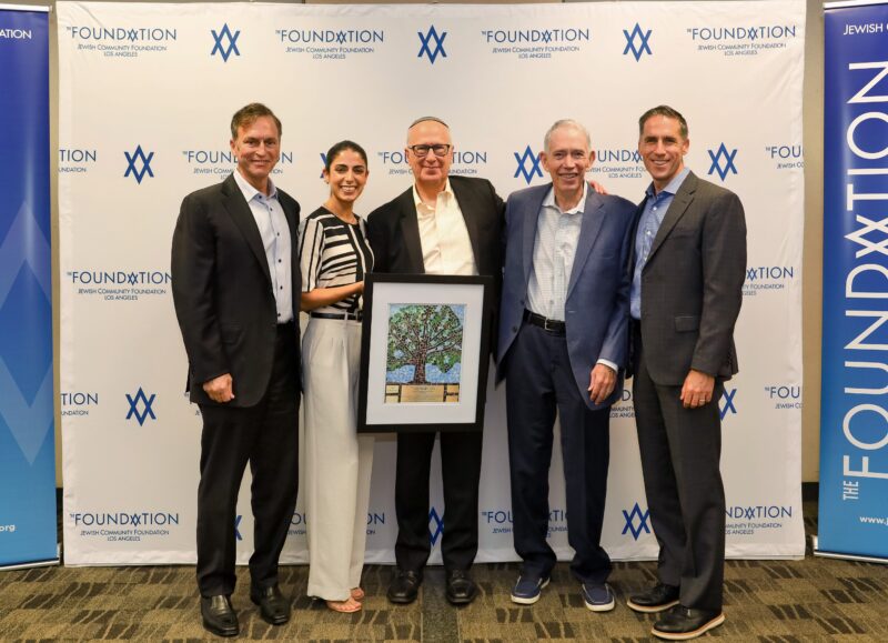 Dr. Bruce Powell (center), dean of the School for Jewish Education and Leadership at American Jewish University, receives the inaugural Marvin I. Schotland Leadership Award from the Jewish Community Foundation of Los Angeles. Schotland (second from right), the longtime president and CEO of The Foundation, retired at the end of 2022. Pictured with Powell and Schotland are (from left): Evan Schlessinger, Foundation board chair; Daniella Kahen, trustee; and Rabbi Aaron Lerner, Foundation president and chief executive officer.