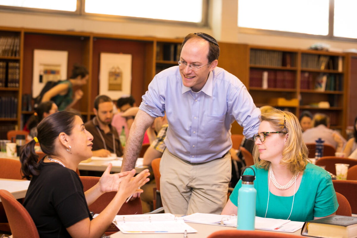 Eliezer "Elie" Kaunfer, president and CEO of Hadar Institute in Manhattan, speaks to two students.