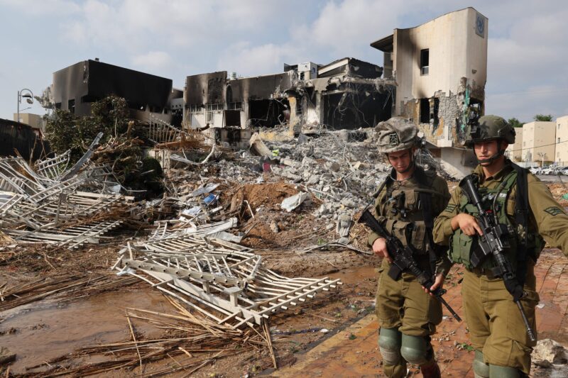 Israeli soldiers walk in front of an Israeli police station in the town of Sderot that was damaged during battles to dislodge Hamas terrorists inside, on Oct. 8, 2023.