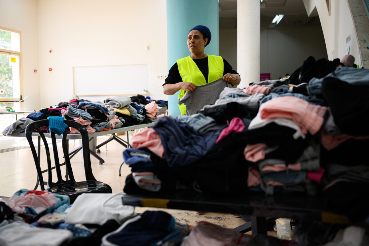 

An Israeli woman folds and sorts clothing that has been collected for people displaced by the war between Israel and the Hamas terror group in a community center in the central Israeli city of Beit Shemesh yesterday. 