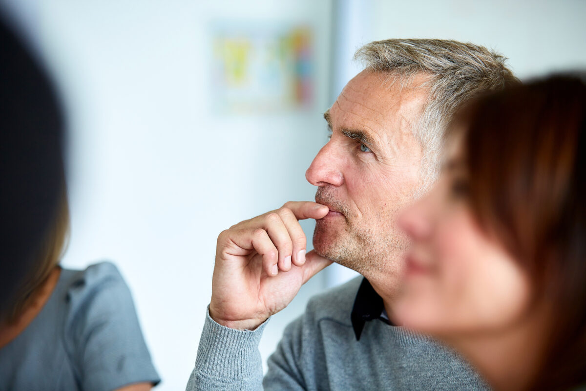 middle aged man listening attentively during meeting